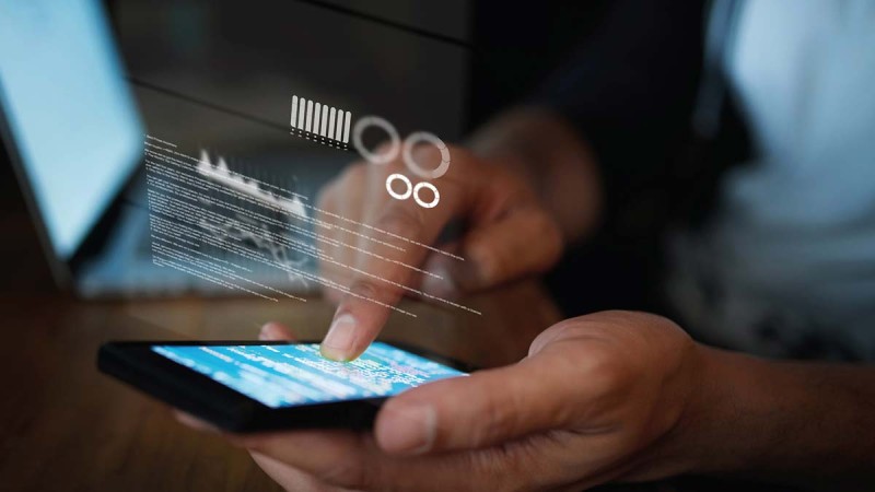 Close-up of a person holding a smartphone in one hand and operating it with the other