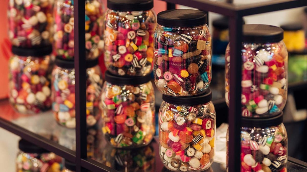 Glasses filled with sweets on a shelf.